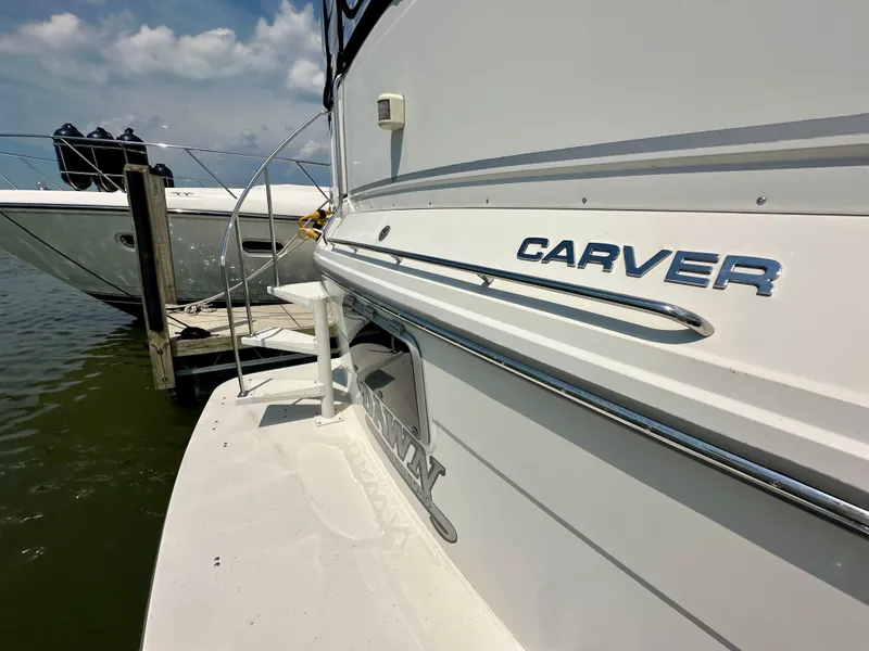 Slide: The Image of 1995 Carver 440 Aft Cabin Motor Yacht docked, showing rear deck and ladder. - 8