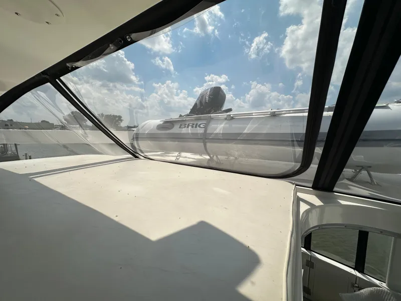 Slide: The Image of 1995 Carver 440 Aft Cabin Motor Yacht interior with view of inflatable boat and clear skies. - 13
