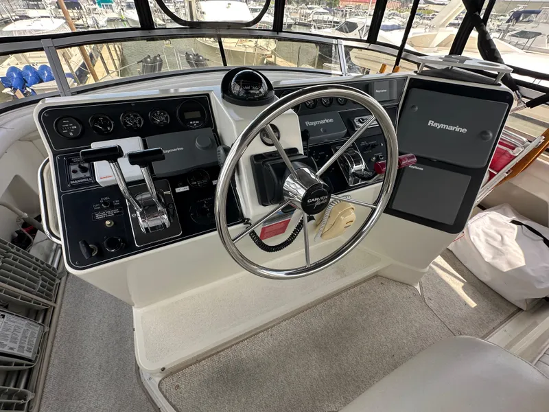 Slide: The Image of 1995 Carver 440 Aft Cabin Motor Yacht interior with white seating and helm view. - 15