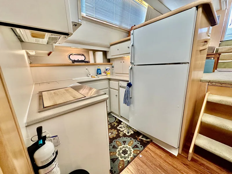 Slide: The Image of 1995 Carver 440 Aft Cabin Motor Yacht interior with wood cabinets and cozy bedding. - 35