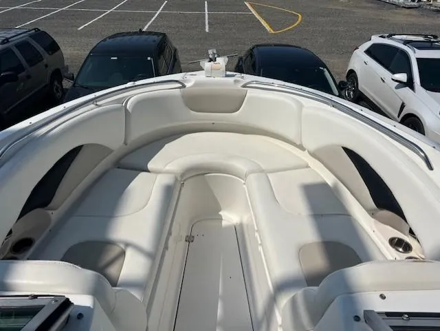 Slide: The Image of 2008 Chaparral SSX 276 boat with spacious white seating, parked near SUVs. - 14