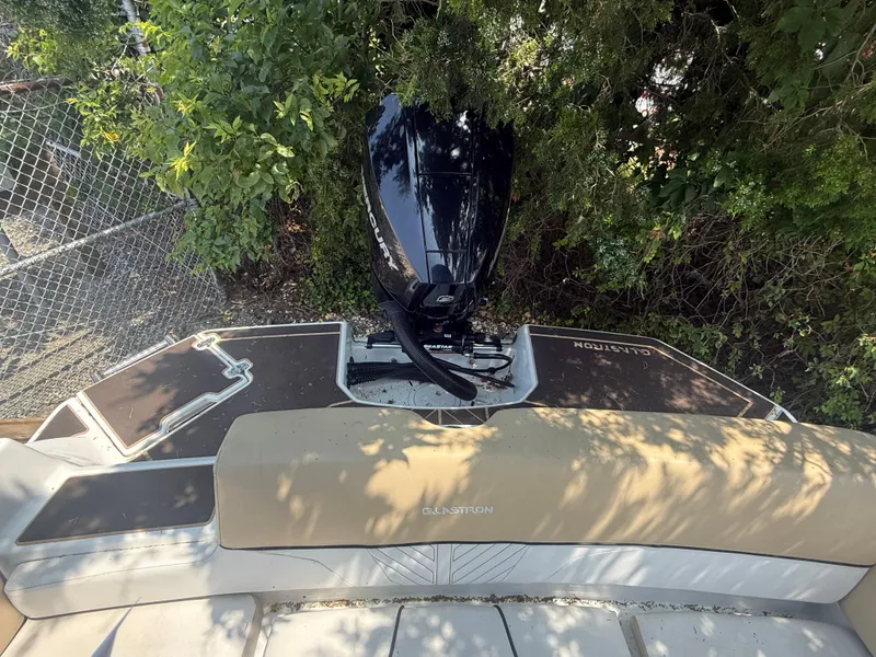 Slide: The Image of 2022 Glastron GTD 220 boat with outboard motor, surrounded by greenery. - 12