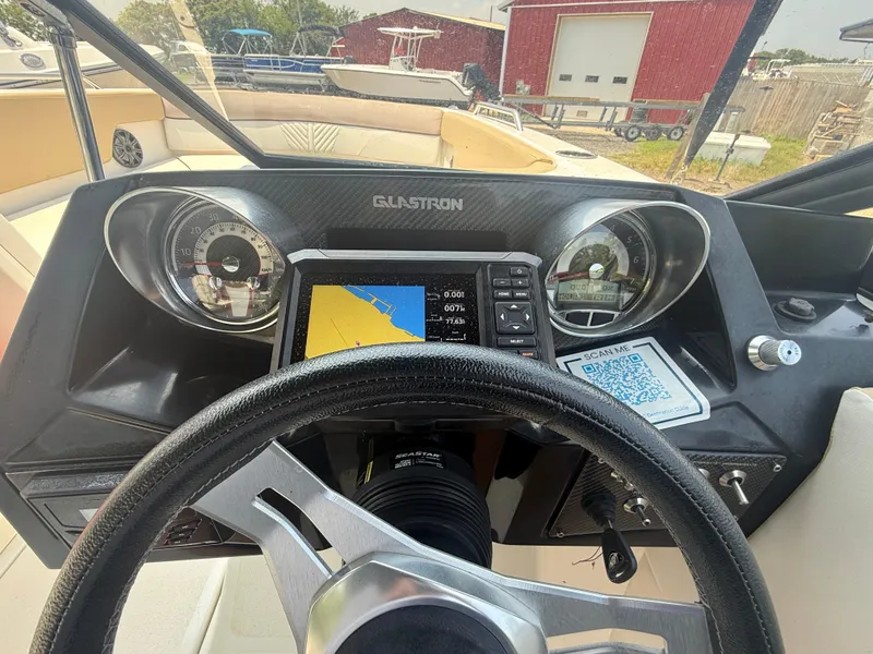 Slide: The Image of 2022 Glastron GTD 220 dashboard with steering wheel, gauges, and navigation system. - 14