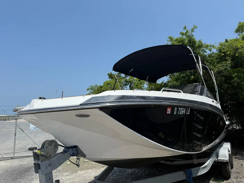 Slide: The Image of 2022 Glastron GTD 220 boat on trailer, black hull, parked outdoors. - 3