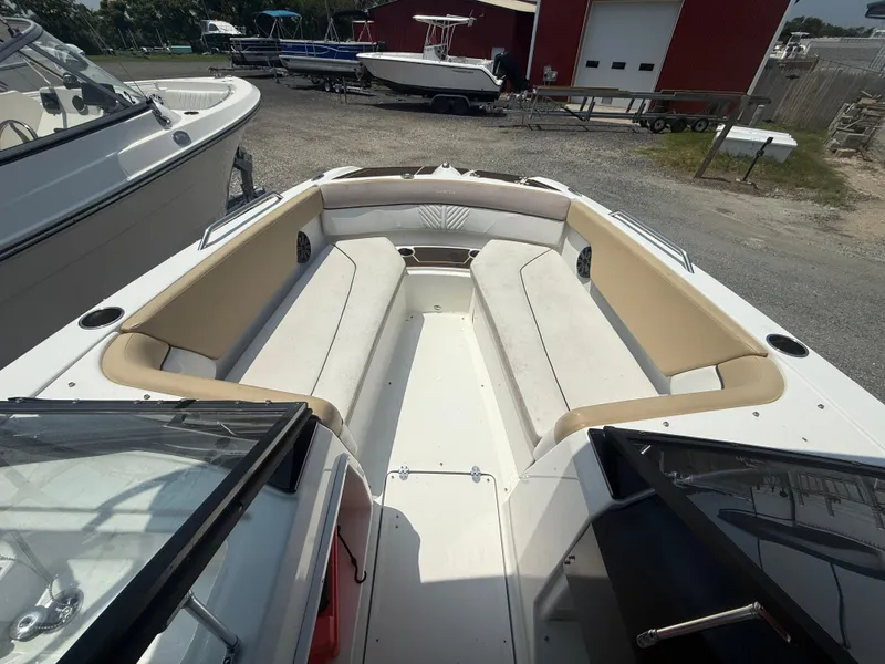 Slide: The Image of 2022 Glastron GTD 220 boat interior with beige seating, docked outdoors. - 5