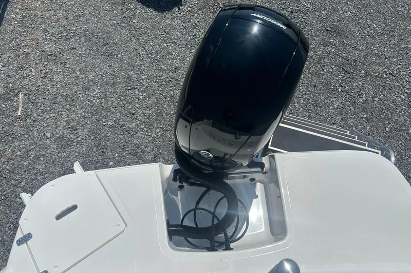 Slide: The Image of 2023 Four Winns H1 OB boat with Mercury outboard motor on gravel surface. - 24