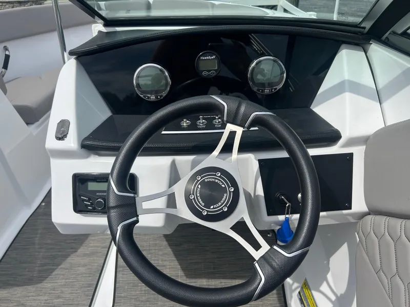 Slide: The Image of 2023 Four Winns H1 OB boat dashboard with steering wheel and gauges. - 25