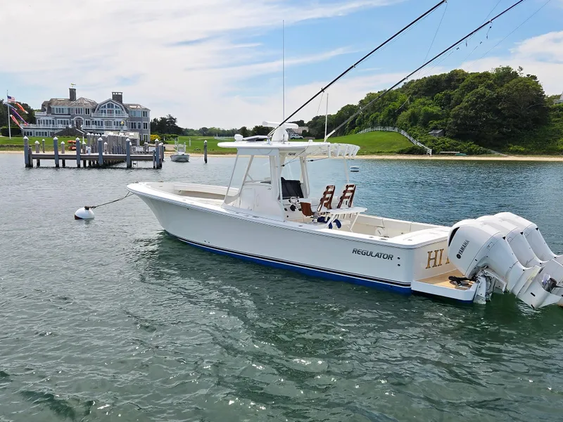 Slide: The Image of 2020 Regulator 34 Center Console boat docked near a coastal mansion. - 3