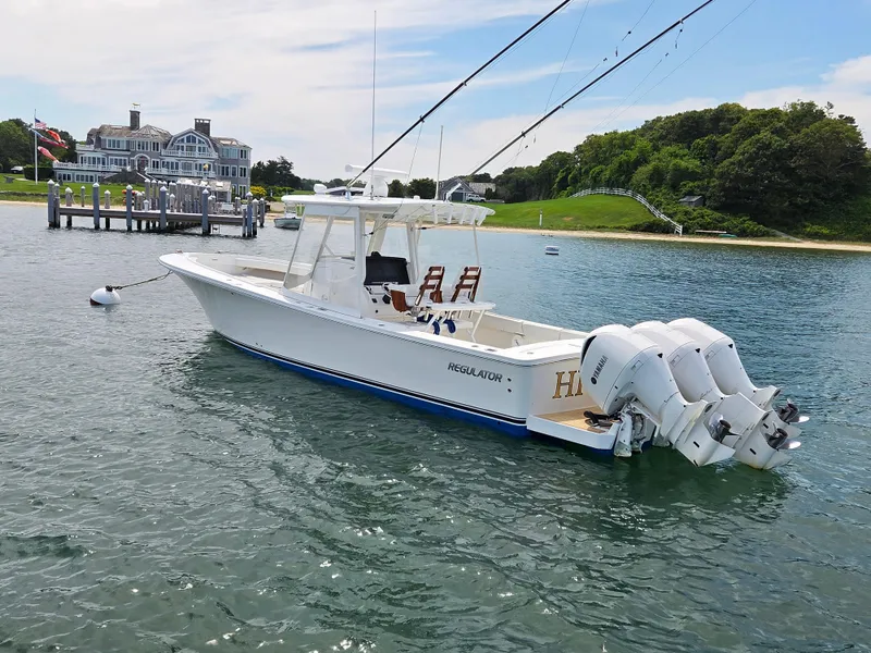 Slide: The Image of 2020 Regulator 34 Center Console boat anchored in a scenic harbor. - 5