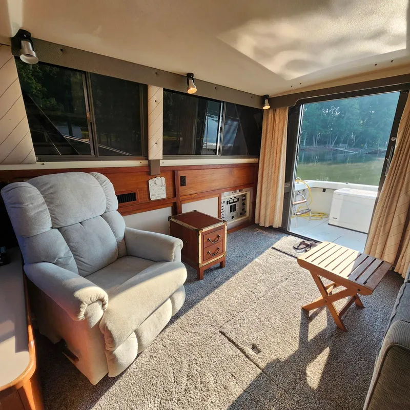 Slide: The Image of Cozy interior of a 1989 Trojan F36 boat with recliner and lake view. - 11