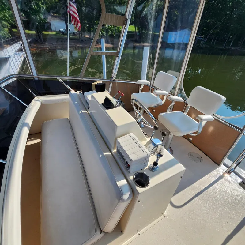 Slide: The Image of 1989 Trojan F36 boat interior with seating, helm, and lake view. - 12