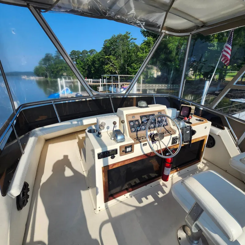 Slide: The Image of 1989 Trojan F36 boat cockpit with steering wheel, control panel, and lake view. - 13