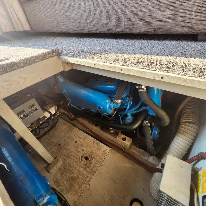 Slide: The Image of Engine compartment of a 1989 Trojan F36 boat, featuring a blue engine and surrounding components. - 14