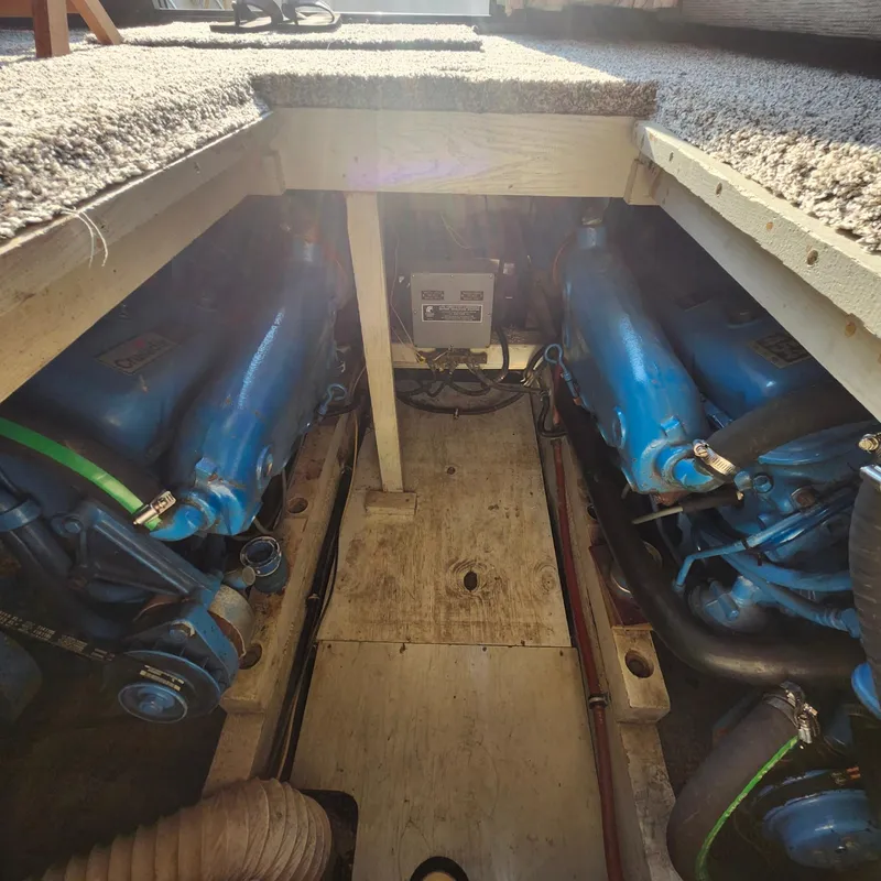 Slide: The Image of Engine compartment of a 1989 Trojan F36 boat, featuring dual blue engines. - 15