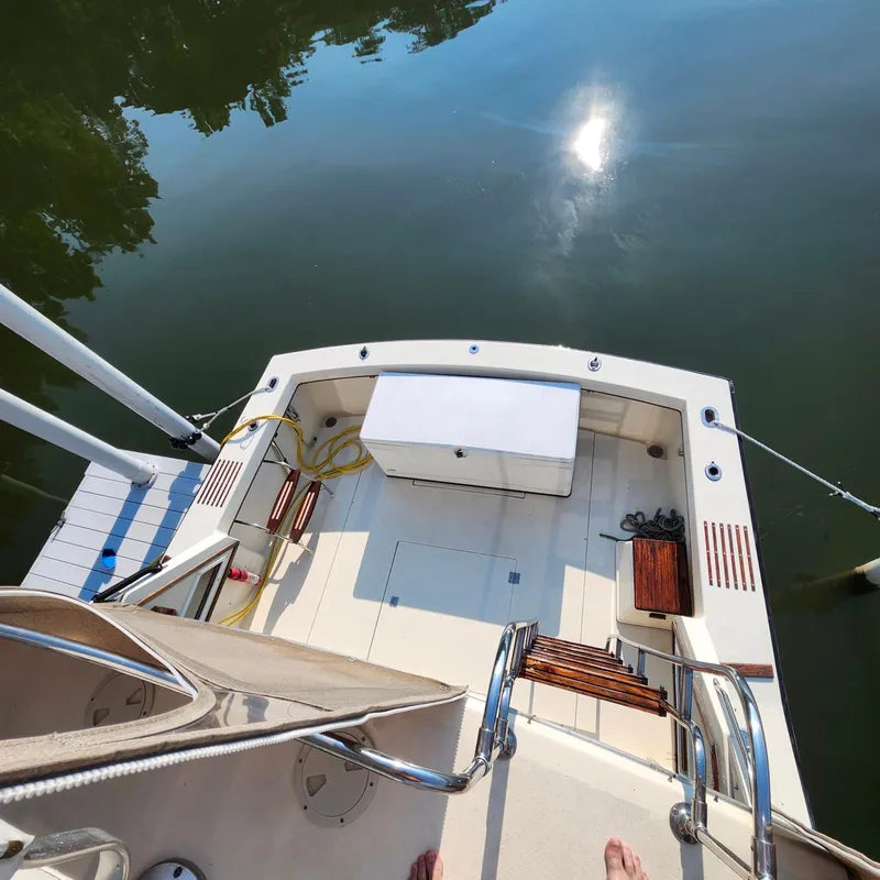 Slide: The Image of 1989 Trojan F36 boat deck with seating, storage, and water reflection. - 21