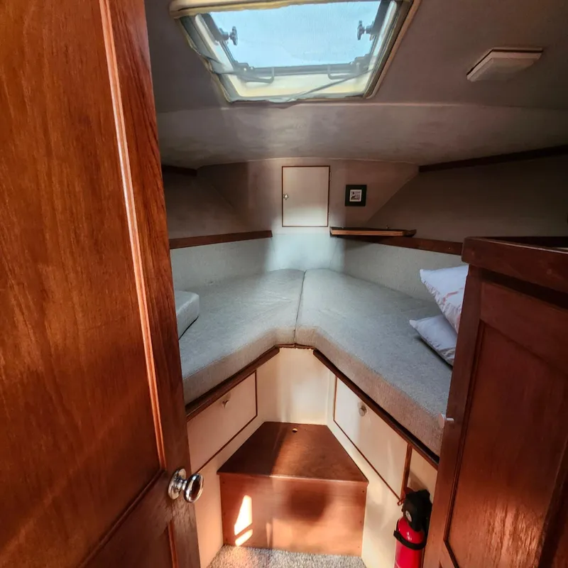 Slide: The Image of 1989 Trojan F36 boat cabin interior with wooden finish and overhead hatch. - 4