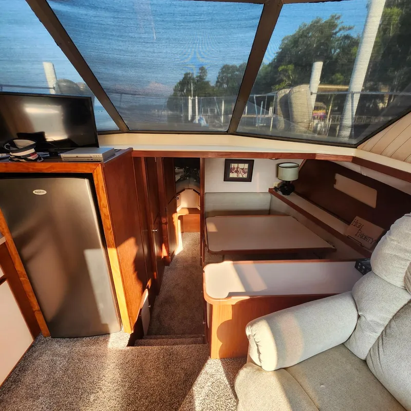 Slide: The Image of Interior of a 1989 Trojan F36 boat with cozy seating and natural light. - 5