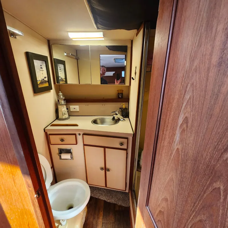 Slide: The Image of 1989 Trojan F36 boat bathroom with sink, toilet, and wooden cabinetry. - 6