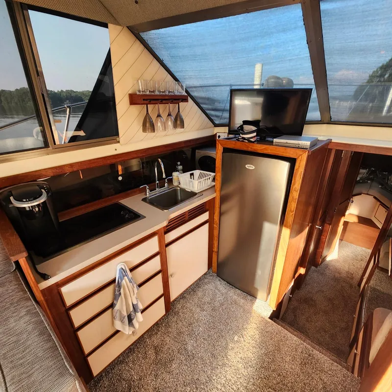Slide: The Image of Interior of 1989 Trojan F36 yacht with kitchenette, sink, fridge, and TV. - 8