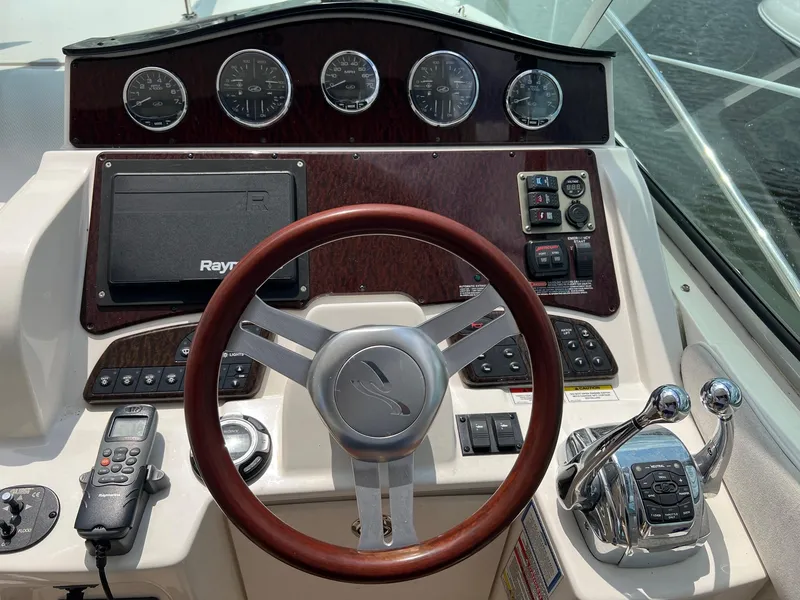 Slide: The Image of Control panel of a 2010 Sea Ray 330 Sundancer boat with steering wheel and gauges. - 14