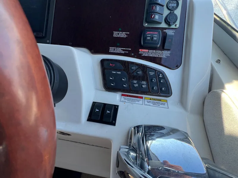 Slide: The Image of Control panel of a 2010 Sea Ray 330 Sundancer boat with steering wheel and switches. - 15