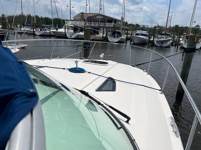 Slide: The Image of 2010 Sea Ray 330 Sundancer docked at marina with sailboats in background. - 19