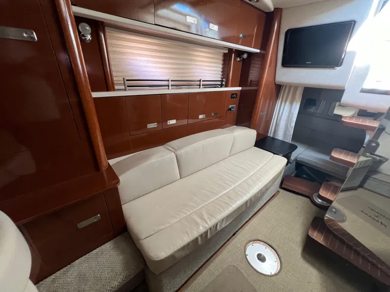 Slide: The Image of Interior of 2010 Sea Ray 330 Sundancer with sofa, TV, and wooden cabinetry. - 26
