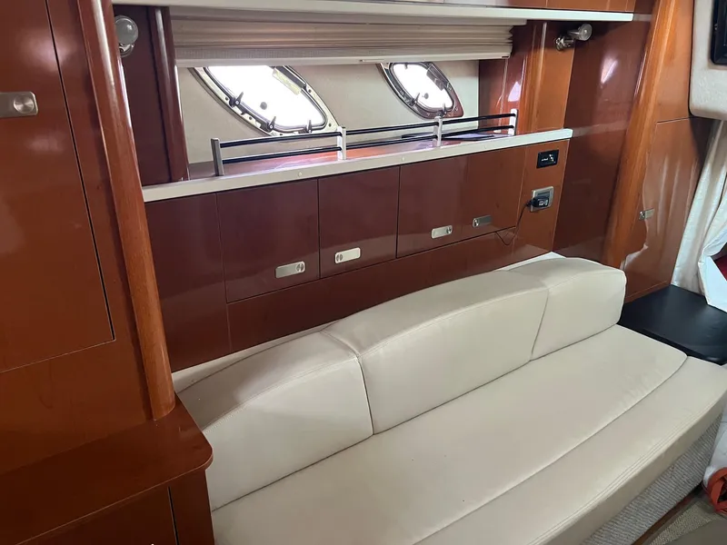 Slide: The Image of Interior of 2010 Sea Ray 330 Sundancer with beige sofa and wooden cabinetry. - 27