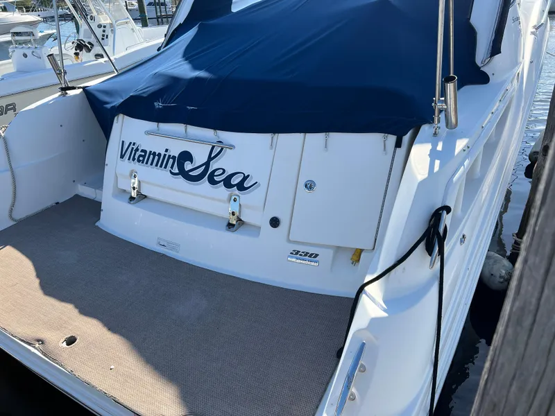 Slide: The Image of Sea Ray 330 Sundancer 2010 boat with "Vitamin Sea" name, docked with blue cover. - 4