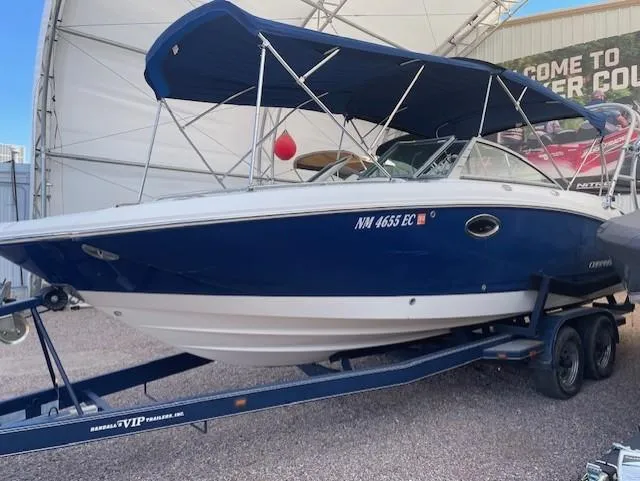 Slide: The Image of 2008 Chaparral Sunesta 264 boat on trailer with blue canopy in storage facility. - 2