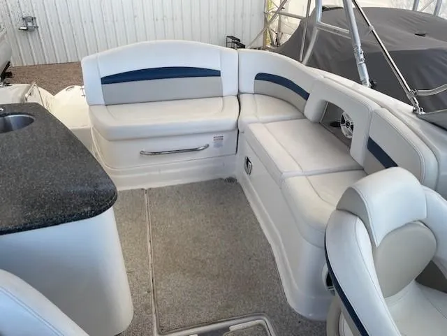 Slide: The Image of 2008 Chaparral Sunesta 264 boat interior with white seating and a black countertop. - 5