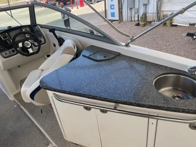 Slide: The Image of 2008 Chaparral Sunesta 264 boat interior with steering wheel and kitchenette. - 6