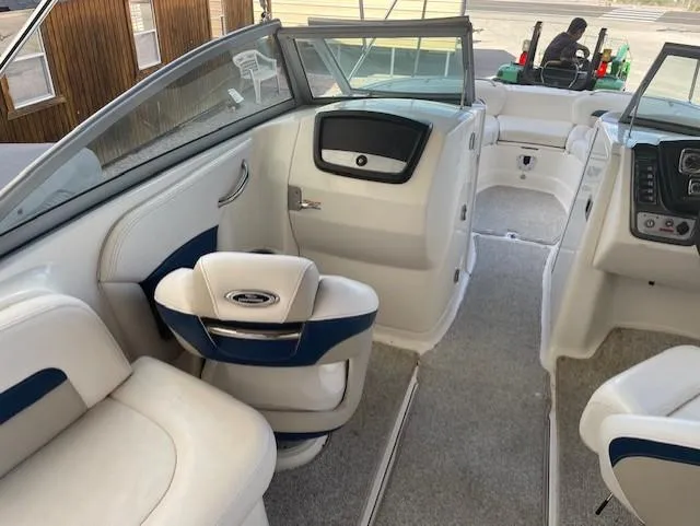 Slide: The Image of 2008 Chaparral Sunesta 264 boat interior with white and blue seating, dashboard, and open deck. - 7
