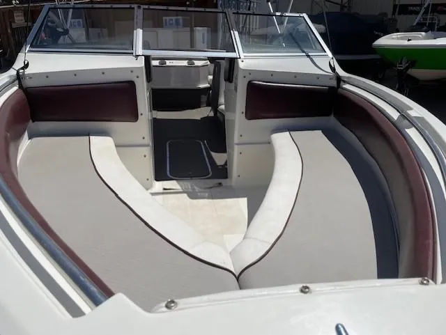 Slide: The Image of 1990 Larson 190 I/O boat interior with cushioned seating and windshield. - 7