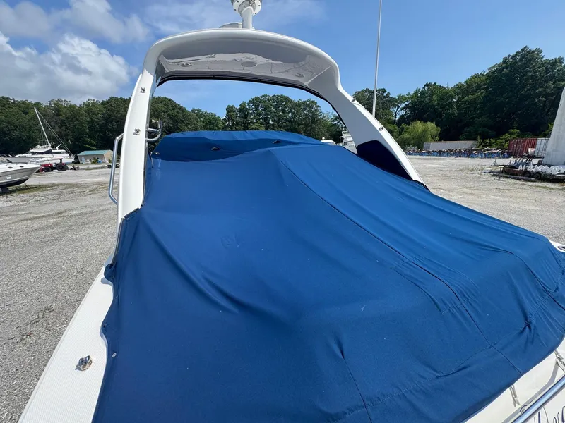 Slide: The Image of 2014 Sea Ray 330 Sundancer covered with blue tarp in outdoor storage area. - 15