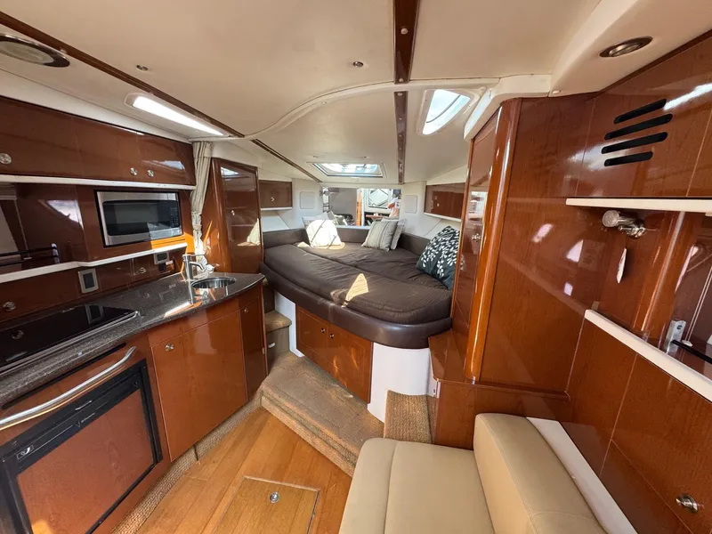 Slide: The Image of Interior of 2014 Sea Ray 330 Sundancer yacht with modern kitchen and cozy sleeping area. - 18