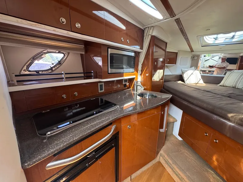 Slide: The Image of Luxurious interior of 2014 Sea Ray 330 Sundancer yacht with kitchenette and cozy seating area. - 19