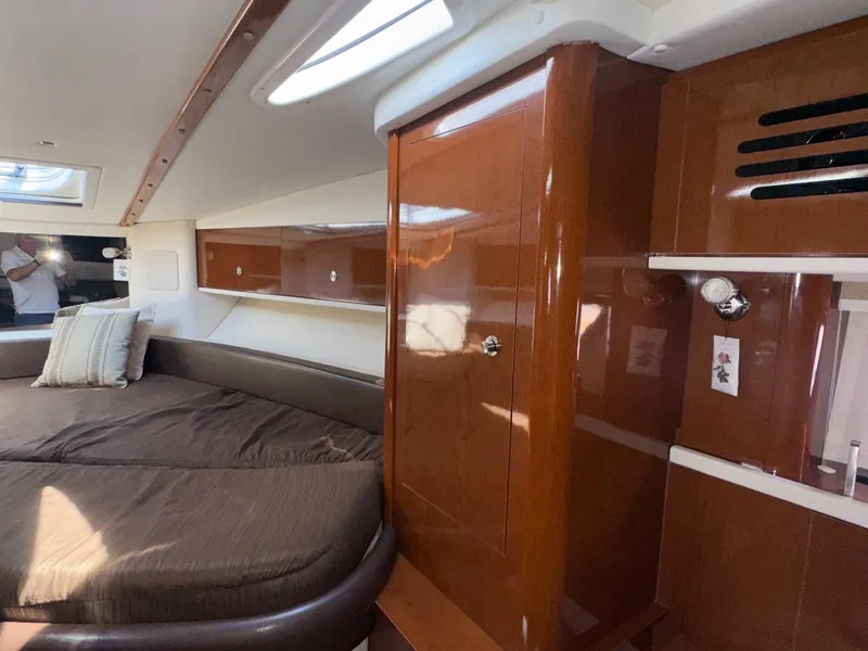 Slide: The Image of Interior cabin of 2014 Sea Ray 330 Sundancer with wood finish and cozy bedding. - 22