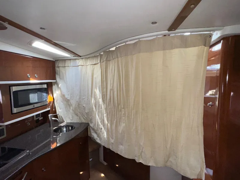 Slide: The Image of Interior of 2014 Sea Ray 330 Sundancer with kitchenette and curtain divider. - 23