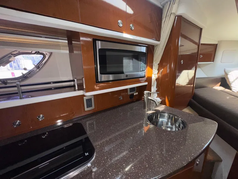 Slide: The Image of 2014 Sea Ray 330 Sundancer interior with kitchenette, microwave, and sink. - 28