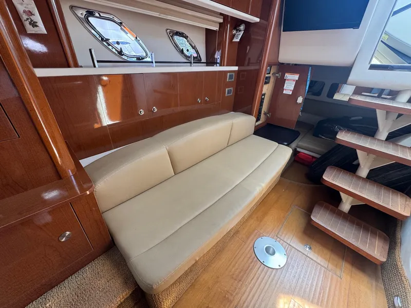 Slide: The Image of Interior of 2014 Sea Ray 330 Sundancer with beige sofa and wooden cabinetry. - 33