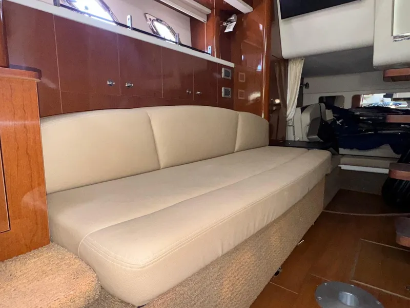 Slide: The Image of Interior of 2014 Sea Ray 330 Sundancer with beige seating and wooden cabinetry. - 34