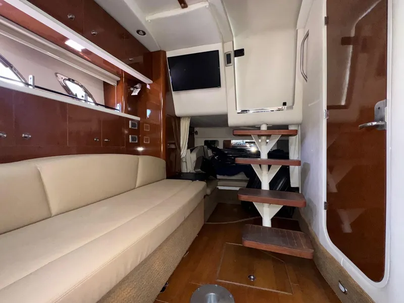 Slide: The Image of Interior of 2014 Sea Ray 330 Sundancer with beige seating and wooden steps. - 35