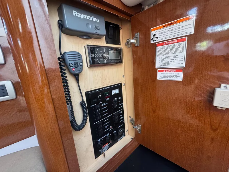 Slide: The Image of 2014 Sea Ray 330 Sundancer control panel with Raymarine equipment and warning labels. - 36