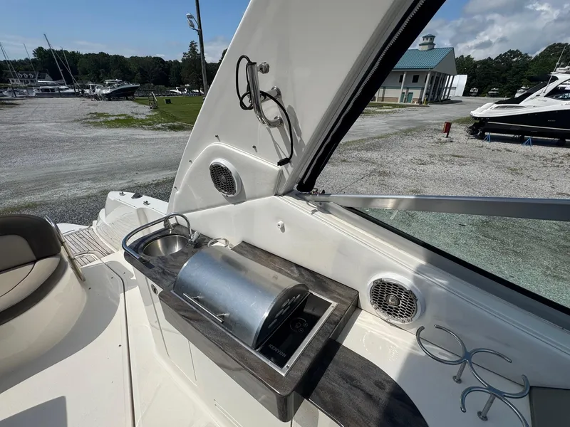Slide: The Image of 2014 Sea Ray 330 Sundancer boat interior with sink and grill on deck. - 9