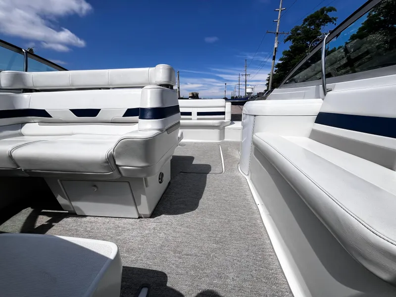 Slide: The Image of 1999 Formula 33 SS boat interior with white seating and blue accents under a clear sky. - 13