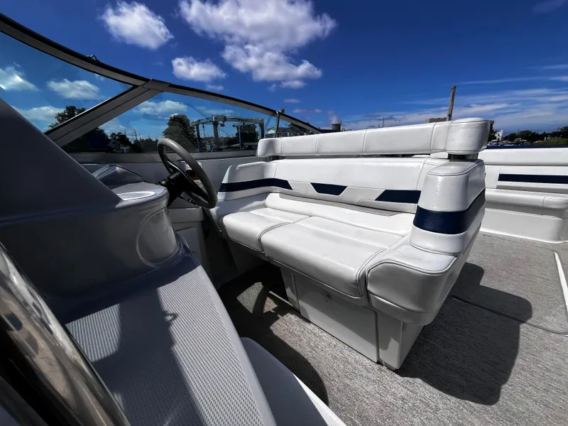 Slide: The Image of 1999 Formula 33 SS boat interior with white seating and steering wheel under blue sky. - 14