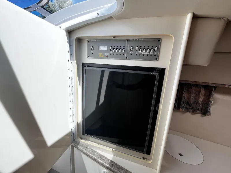 Slide: The Image of 1999 Formula 33 SS boat interior with control panel and Norcold refrigerator. - 23
