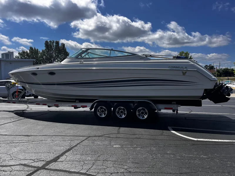 Slide: The Image of 1999 Formula 33 SS boat on trailer under blue sky with clouds. - 5