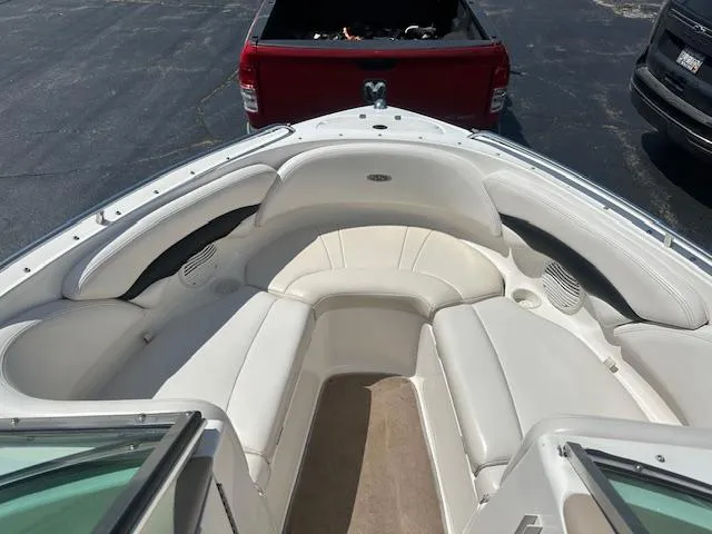 Slide: The Image of 2002 Chaparral 196 SSi boat interior with white seating, parked near a red truck. - 12